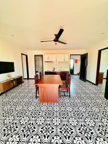 a living room with a table and a kitchen at Laa House in Hoi An