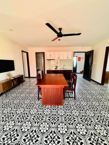 a living room with a table and a kitchen at Laa House in Hoi An