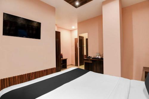 a bedroom with a bed and a television on the wall at Hotel O Park Circus in Kolkata