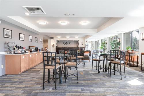 a dining room with tables and chairs and a counter at Marshall Suites Bainbridge Island, SureStay Collection by BW in Bainbridge