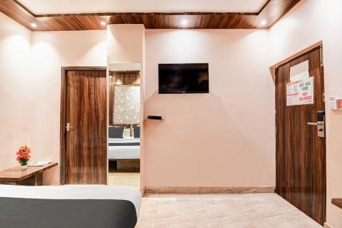 a room with a bed and a tv on the wall at Hotel O Park Circus in Kolkata
