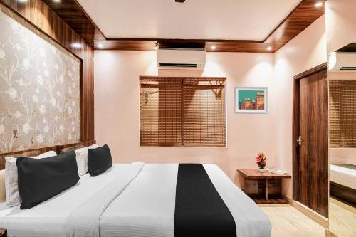 a bedroom with a large bed and a tub at Hotel O Park Circus in Kolkata