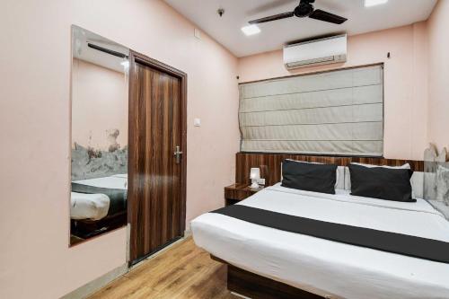a bedroom with a large bed and a bathroom at Hotel O Park Circus in Kolkata