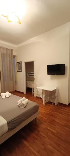 a bedroom with a bed and a desk and a television at Casa Flora in Taranto