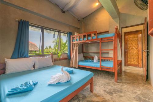 a bedroom with a bed with two bunk beds at Sinag Hostel in General Luna