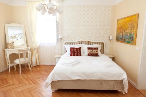 a bedroom with a large white bed with pillows at Benecanka Casa Veneziana Piran in Piran