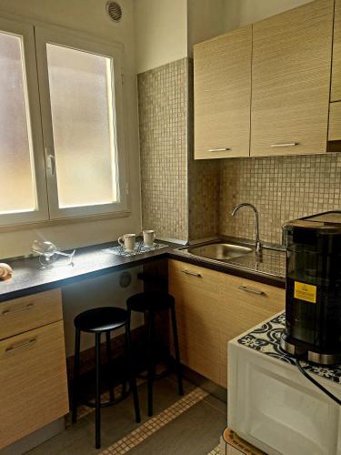 a kitchen with two bar stools and a sink at Casa Flora in Taranto