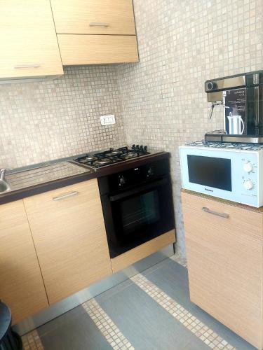 a kitchen with a stove and a microwave at Casa Flora in Taranto