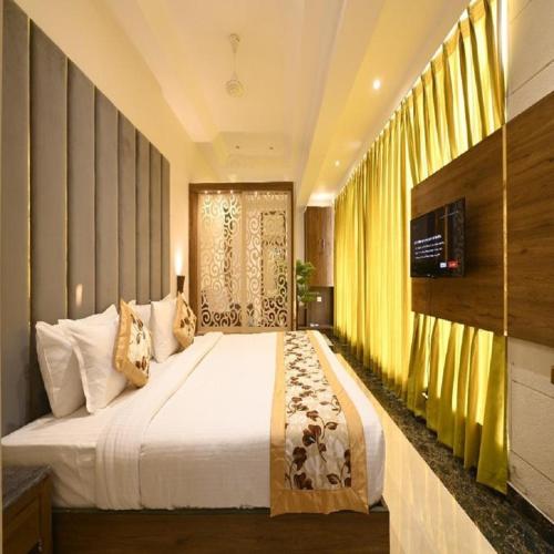 a bedroom with a large bed and a large window at Hotel Avalon Palms Agra in Agra