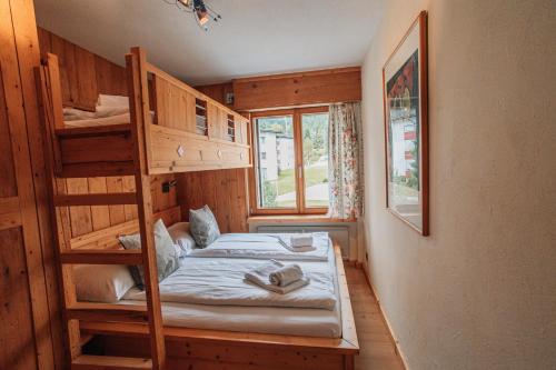 a bedroom with two bunk beds and a window at LAAX Homes - Casa Allgäu in Laax-Murschetg