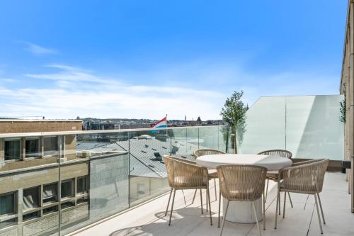 a patio with a table and chairs on a balcony at Voya Residence Zenit Royal - Luxury Apart Hotel Rooftop Views & Concierge in Luxembourg