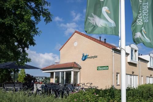 a building with two flags in front of it at Resort Boschmolenplas in Heel