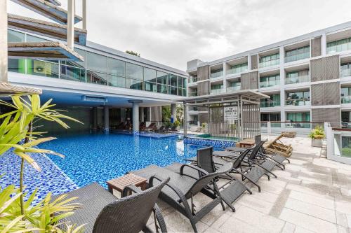 a swimming pool in front of a building at Majestic 2BR Residence with garden view in Regent in Bang Tao Beach