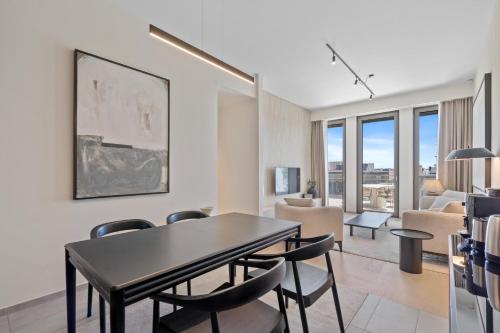 a living room with a dining room table and chairs at Voya Residence Zenit Royal - Luxury Apart Hotel Rooftop Views & Concierge in Luxembourg