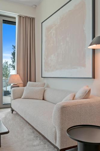 a living room with a couch and a large painting at Voya Residence Zenit Royal - Luxury Apart Hotel Rooftop Views & Concierge in Luxembourg