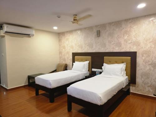 a hotel room with two beds and azeb sidx sidx sidx sidx sidx at MG Beatle Hotel Tirupati in Tirupati