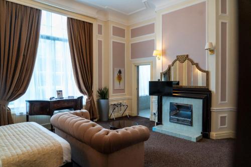 a hotel room with a couch and a fireplace at Adelphi Hotel in Liverpool