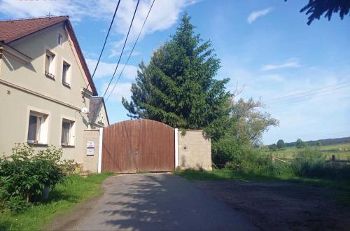 a house with a wooden gate next to a tree at Foistovic Ranč in Staré Sedlo