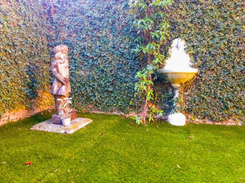 a garden with a fountain in front of a wall at Villino Lavarello in Verbania
