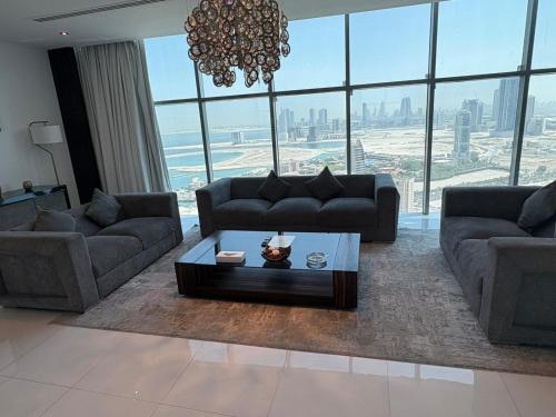 a living room with couches and a chandelier at Seef View Apartments in Manama