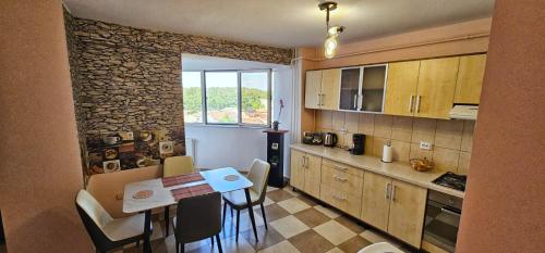 a kitchen with a table and chairs and a stone wall at Casa Vasy in Timişoara