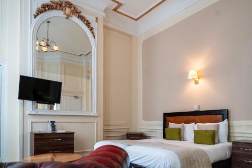 a hotel room with a bed and a mirror at Adelphi Hotel in Liverpool