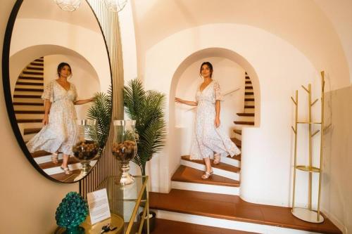 a woman walking down the stairs in a mirror at Le Clarisse Pigna Apartment in Rome