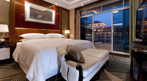 a bedroom with a large bed and a large window at Sheraton Changzhou Wujin Hotel in Changzhou
