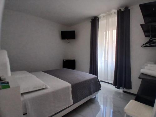 a bedroom with a bed and a large window at La rosa dei pepoli in Castiglione dei Pepoli