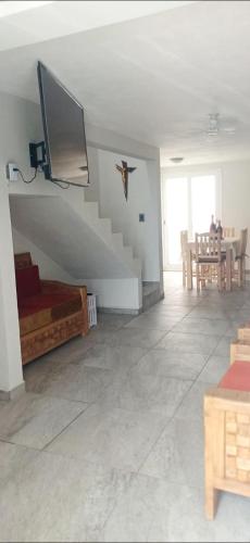 a living room with a staircase and a tv on the wall at Casa del Sol in Toluca