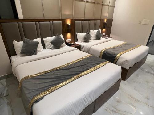 a hotel room with two beds in a room at Hotel Avalon Palms Agra in Agra