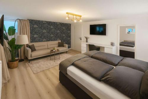 a bedroom with a large bed and a living room at Retreat in besonderem Haus "Eriksson" - FjordStay in Kiel