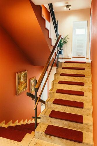 a staircase in a home with orange walls at Retreat in besonderem Haus "Eriksson" - FjordStay in Kiel