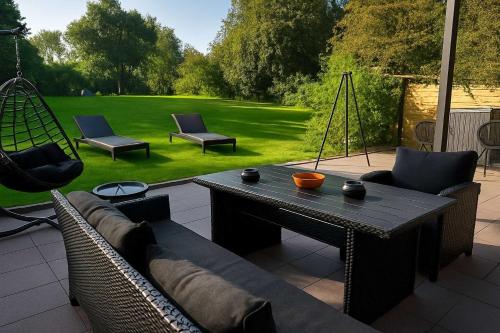 a patio with a couch and chairs and a table at Retreat in besonderem Haus "Da Gama" -FjordStay in Kiel
