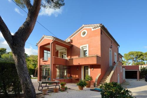 an orange house with a tree in front of it at Nice seaside nest with private garden and carpark in Carry-le-Rouet