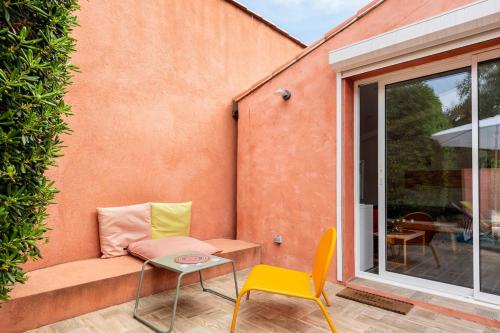 a patio with a bench and a table and a chair at Nice seaside nest with private garden and carpark in Carry-le-Rouet