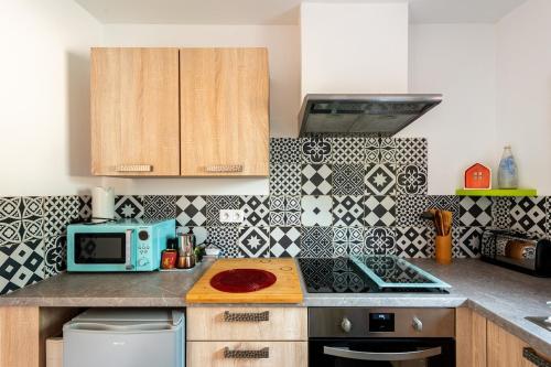 a kitchen with a counter top with a blue microwave at Nice seaside nest with private garden and carpark in Carry-le-Rouet
