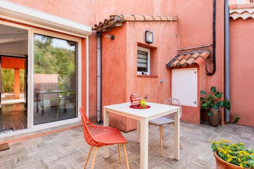 a table and chairs on a patio with a building at Nice seaside nest with private garden and carpark in Carry-le-Rouet