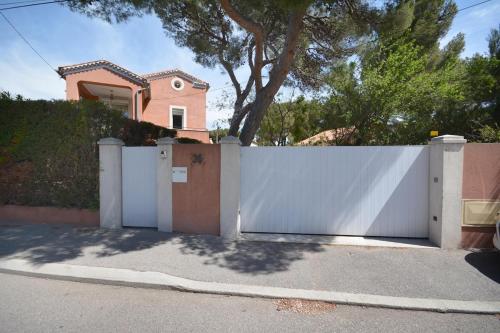 a white fence in front of a house at Nice seaside nest with private garden and carpark in Carry-le-Rouet