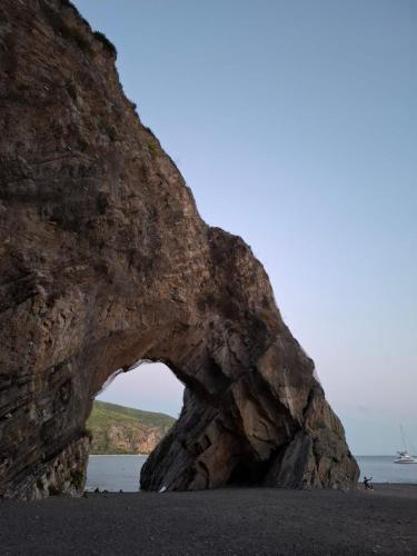 an arch in a rock wall on the beach at B&B IL VECCHIO GELSO in Palinuro