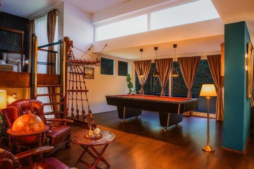 a living room with a pool table and a staircase at Retreat in besonderem Haus "Magellan" - FjordStay in Kiel