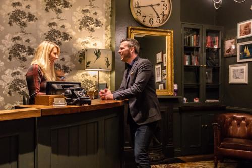 a man and a woman standing at a counter at The Windmill On The Common in London