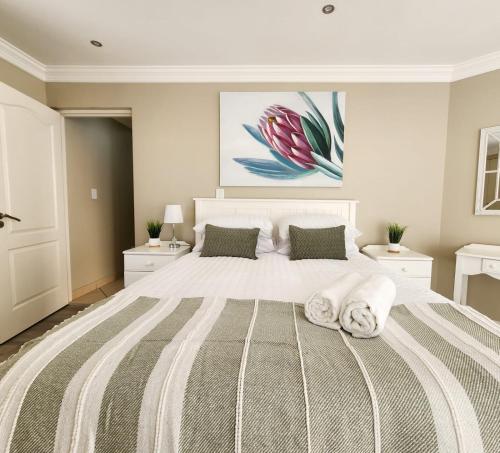 a bedroom with a large white bed with two pillows at Surf & Serenity on Sea, by Jono & Erik in Jeffreys Bay