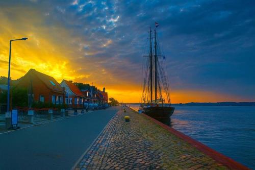 a boat is parked on the side of the water at Retreat in besonderem Haus "Polo" - FjordStay in Kiel