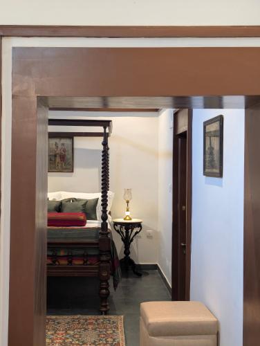 a bedroom with a canopy bed and a table at Nilayam by Luxunlock Private Villas in Jāmb