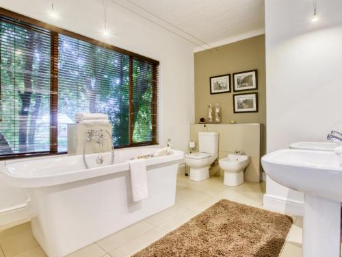 a bathroom with a tub and a sink and a toilet at The Residence Boutique Hotel in Pineview