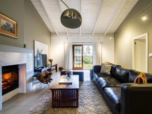 a living room with a leather couch and a fireplace at The Residence Boutique Hotel in Pineview