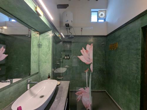 a green bathroom with a tub and a sink and a sink at Nilayam by Luxunlock Private Villas in Jāmb