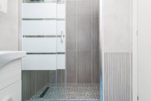 a shower with a glass door in a bathroom at Molino Lounge Express 20' da Milano e Malpensa in Saronno