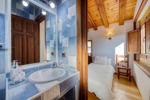 a bathroom with a sink and a bed at Casa Cuesta del Reloj in Piedralaves